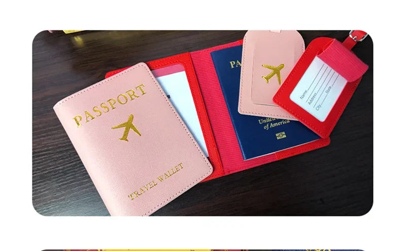 A stack of pink, red, and blue PU leather passport holders with card slots displayed on a dark surface.