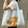 A light blue nylon shopping tote bag featuring a yellow floral design, shown from the front.