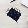 A dark blue zippered card holder wallet is shown on a light wooden surface with dimension lines.