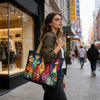 Una mujer con chaqueta verde oliva lleva un colorido bolso acolchado vintage con pájaros pintados mientras camina en un...