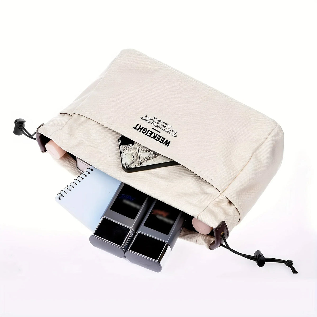 A beige drawstring canvas storage organizer bag is shown holding a black smartphone and a small card.