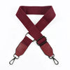 A maroon canvas cotton bag strap with black metal hooks, shown in an X-shape.
