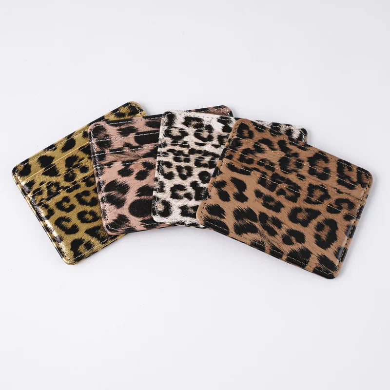 A stack of leopard print PU leather card wallets in various shades of brown and black.