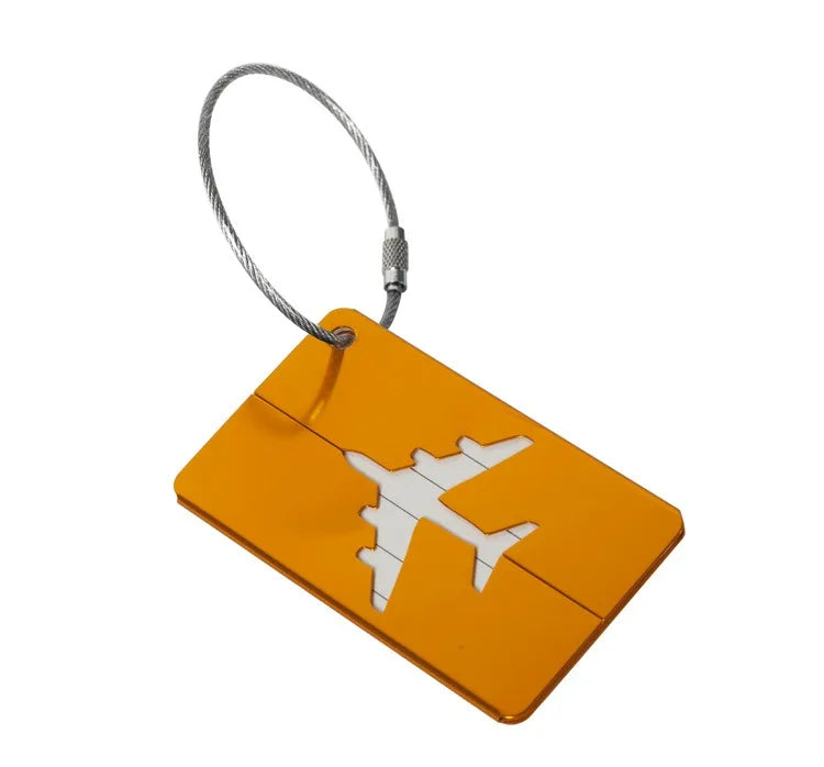 A bright orange aluminum luggage tag with a white airplane silhouette attached to a silver cord.