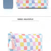 A colorful checkered cosmetic storage pouch with pink, yellow, blue, and white squares and tassels.