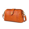 A genuine leather crossbody bag in a warm tan or cognac brown color with a flap and buckle closure.