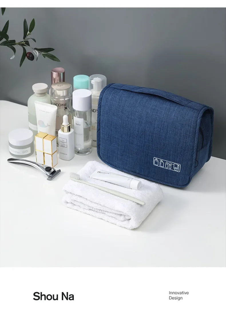 Un sac organisateur en tissu bleu marine avec divers produits de soins de la peau et de beauté sur une surface blanche.