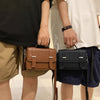 A man holds a brown leather minimalist crossbody bag in his hand.