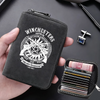 A black zippered card wallet featuring a hunting insignia design is held in a hand next to a stack of credit cards.