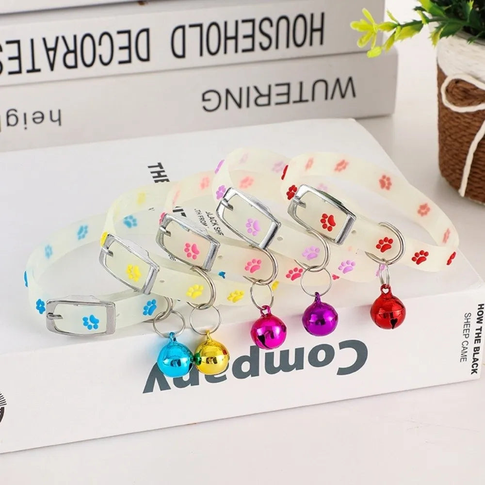 A set of glow-in-the-dark pet collars for dogs and cats featuring various colors and charms displayed on a white background.