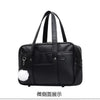Black leather preppy shoulder bag with white fluffy trim shown from the front