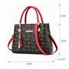 Sac bandoulière en cuir PU rouge et noir à motif avec quincaillerie dorée, vue de profil.