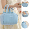 Bolso térmico acolchado azul claro sostenido por una mujer, mostrado desde varios ángulos.