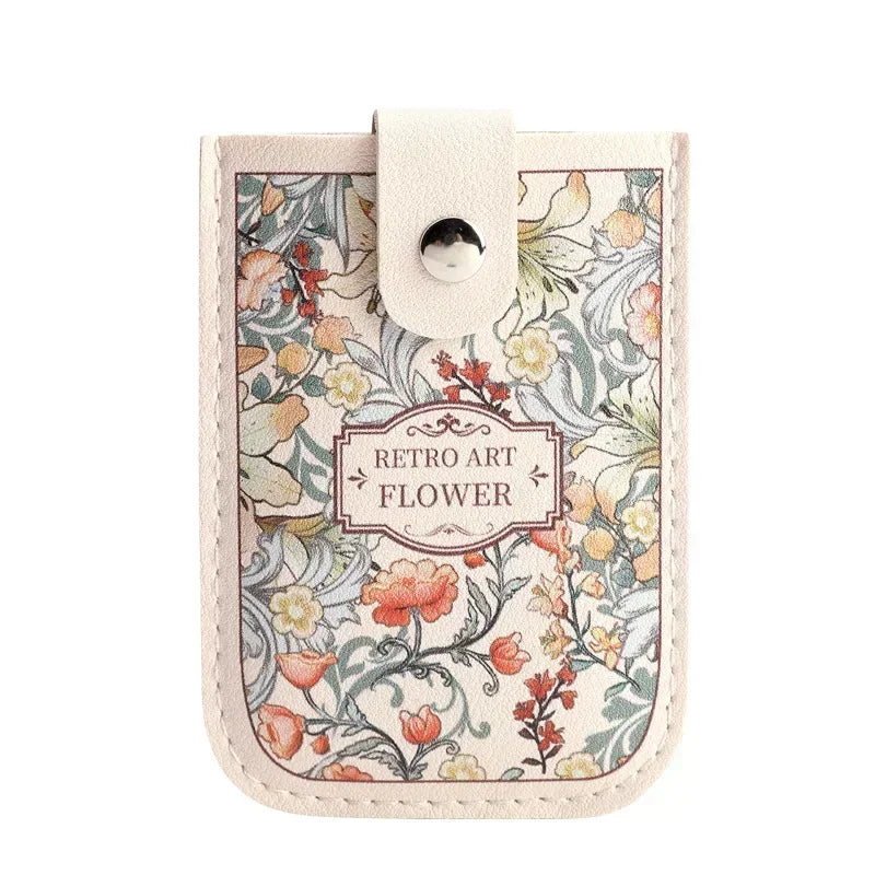 A light pink leather card wallet featuring a vintage floral pattern with orange and yellow flowers.