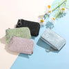 A collection of elegant ladies zip coin purses in black, mint green, and pink, displayed on a light blue background with whit