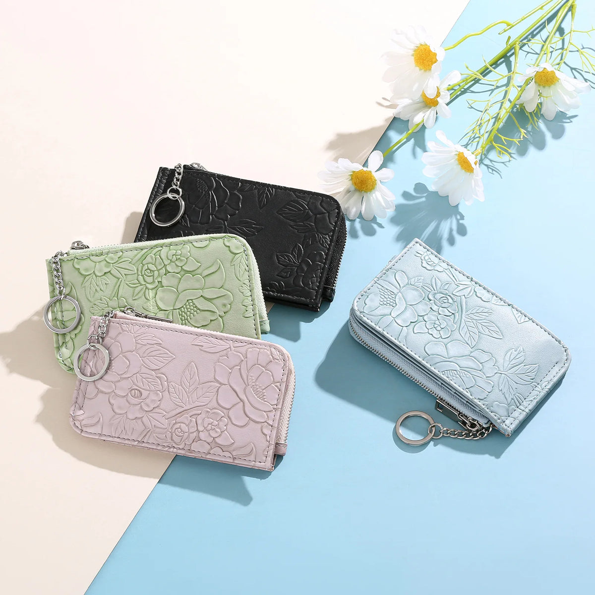 A collection of elegant ladies zip coin purses in black, mint green, and pink, displayed on a light blue background with whit