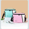 Pink and teal insulated reusable lunch bags with adjustable straps displayed on a white surface.