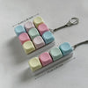A white tactile stress relief keyboard fidget toy with colorful, squishy keys arranged in a row.