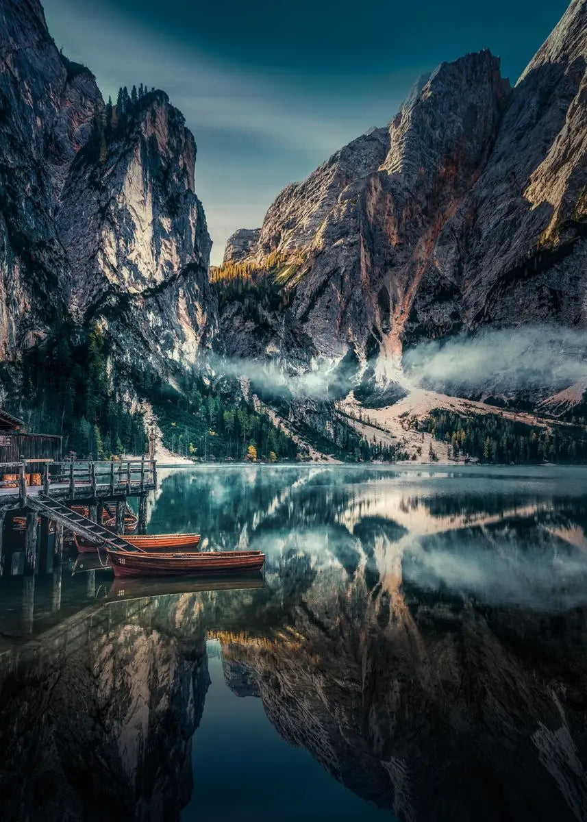 Nebelbedeckte Berglandschaft, die sich in einem ruhigen See spiegelt, mit Holzboot und Waldszenen.