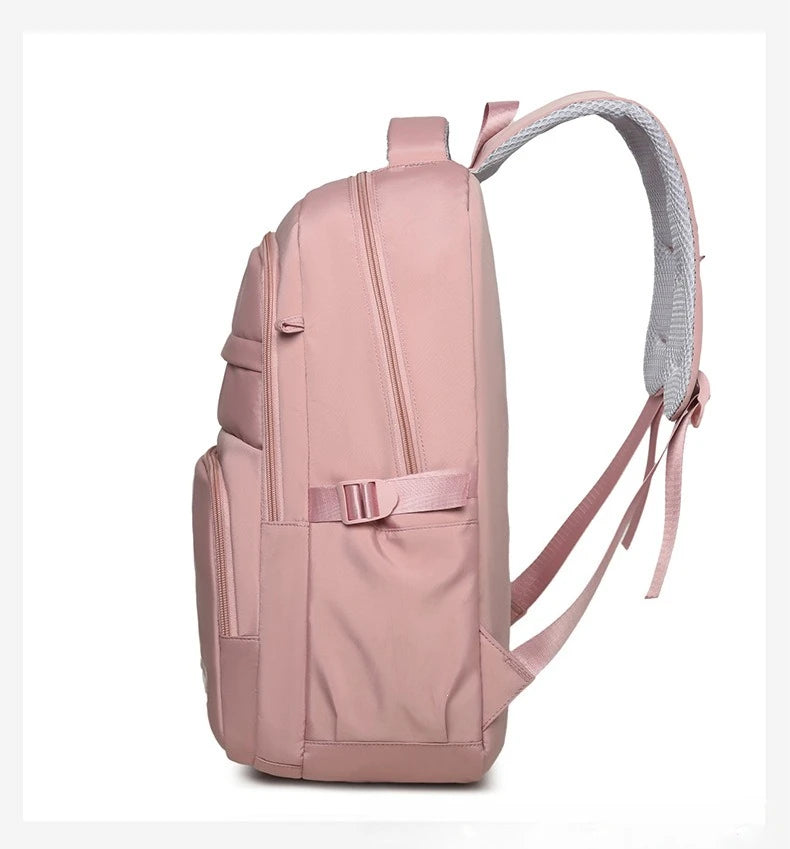 Una mochila rosa claro con correas grises y un bolsillo para portátil.