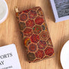 A patterned bohemian wood-grain leather wallet with multiple card slots resting on a wooden surface.