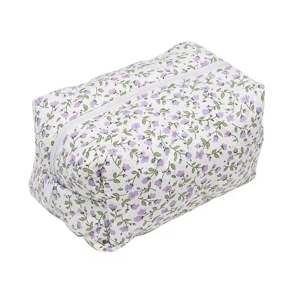 Bolsa de maquillaje con cremallera acolchada floral, fondo blanco y patrón floral morado