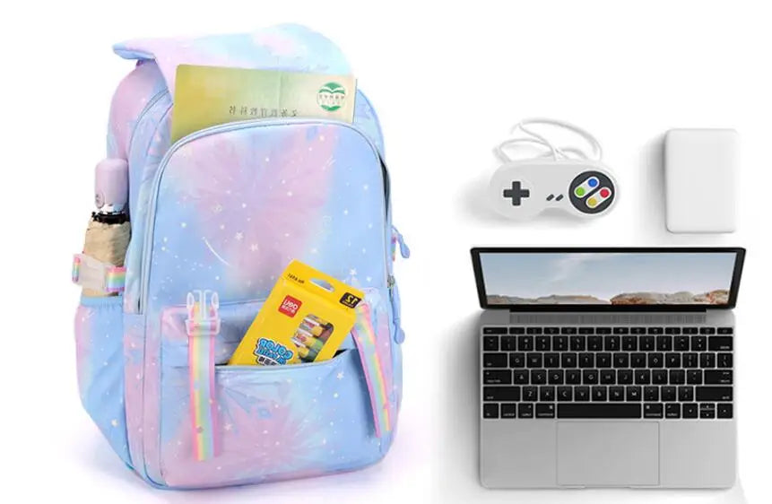 A light blue and pink jacquard laptop backpack with a yellow tag and a silver laptop displayed next to a wireless controller.