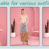 A woman models a beige mesh beach tote with woven shoulder straps in a pink room setting.