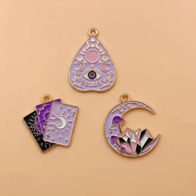 A set of celestial sun moon star tarot charms in purple and gold for jewelry making