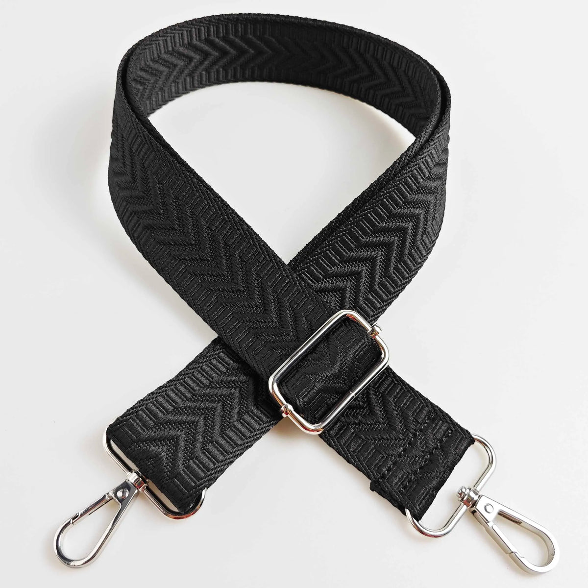 Black adjustable handbag strap featuring an arrow jacquard pattern and silver hardware