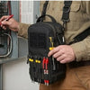A person holds a black tactical shoulder tool pouch with various tools attached, against a light-colored uniform.