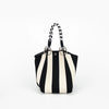 A black and white striped knitted contrast tote handbag with braided handles.