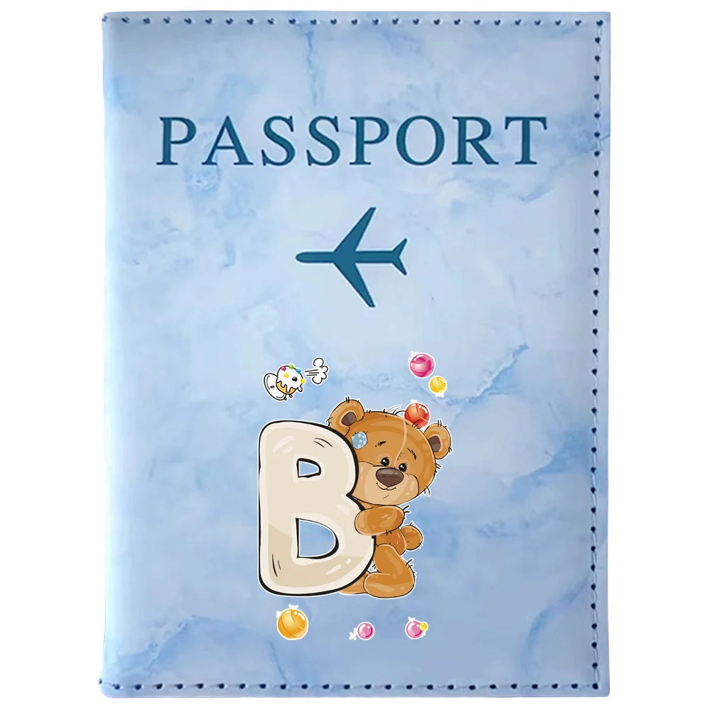 A light blue passport card holder featuring a vintage letter B print and a small airplane icon.