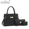 Black leather handbag with gold hardware and a strap displayed on a white background.