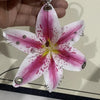 A realistic pink and white orchid flower keychain with silver findings.