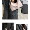 A light pink retro PU leather shoulder bag is shown being held by a woman in a gray suit jacket.
