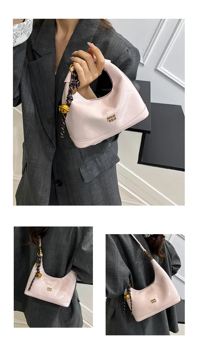 A light pink retro PU leather shoulder bag is shown being held by a woman in a gray suit jacket.
