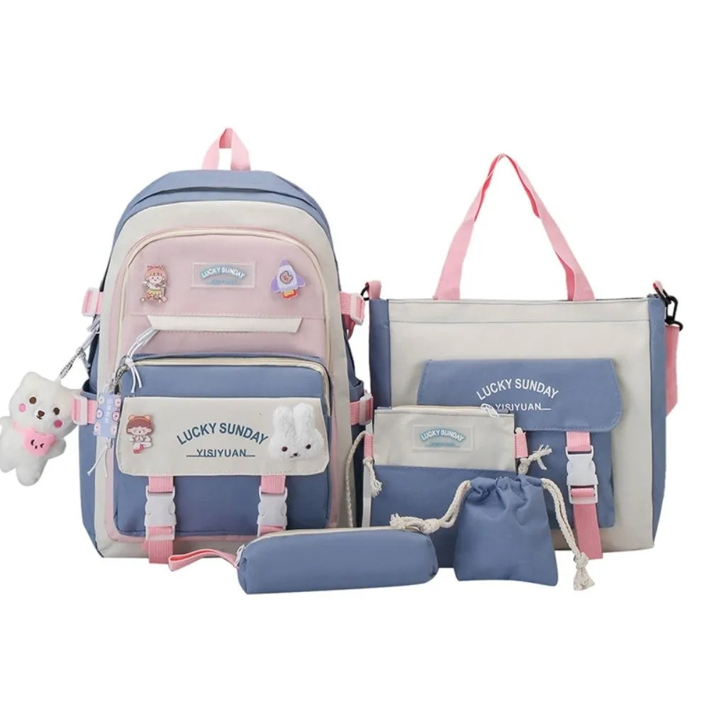 A set of five pastel blue and pink nylon backpacks for students featuring various cartoon designs.