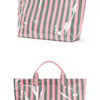 A pink and green striped tote bag featuring an abstract white splatter pattern.