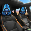 A set of two black headrest covers featuring a glowing blue gothic skull design in a car interior.