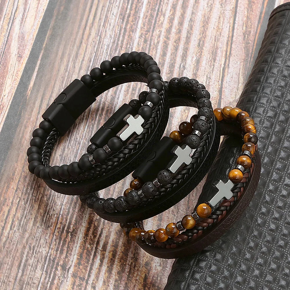 A stack of black leather bracelets featuring tiger eye beads resting on a dark surface.
