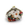 A vintage rose print canvas coin purse with gold-toned hardware.