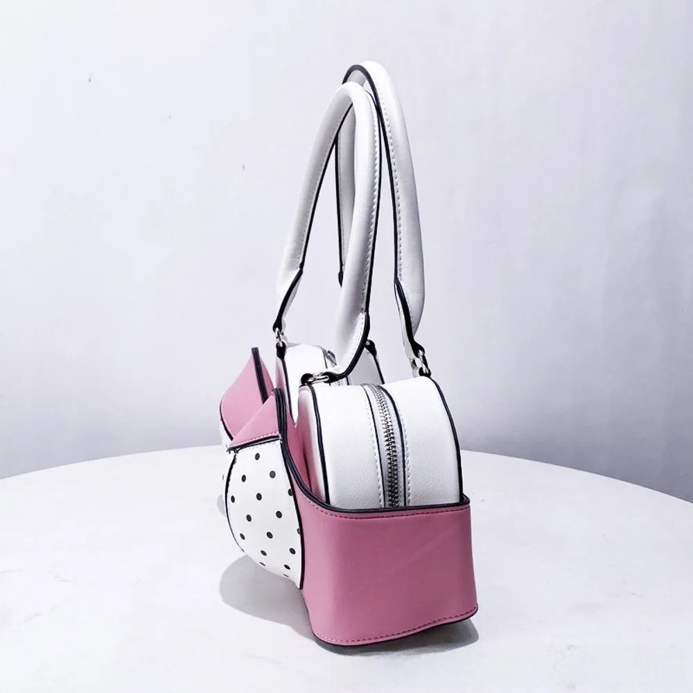 A pink and white shoulder bag featuring a bow silhouette and polka dot accents.