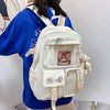 A white Korean style large capacity women's backpack with a padded laptop compartment worn by a person.