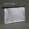 Bolsa transparente para cosméticos con cremallera negra, mostrando herramientas y artículos de belleza dentro.