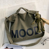 A dark olive green canvas tote bag featuring the word MOOD printed in large, dark letters.
