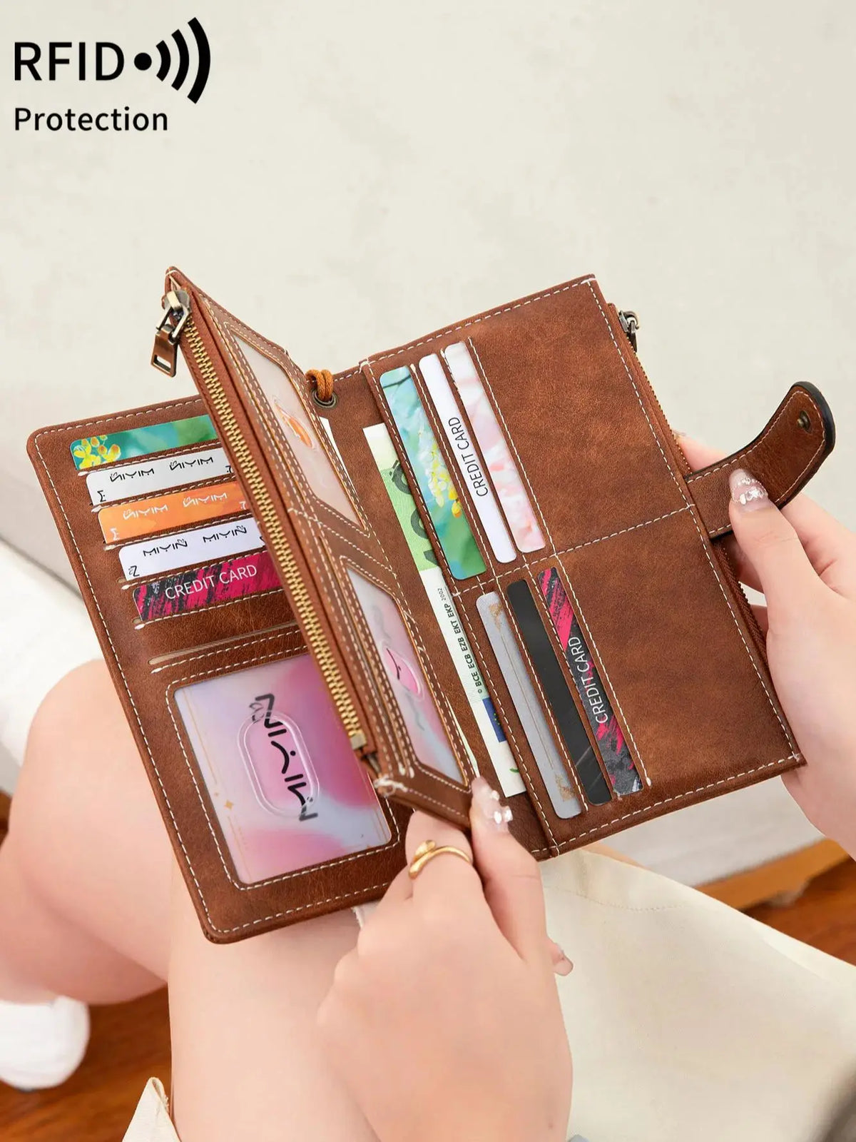 A brown leather trifold clutch wallet is shown open, displaying various cards and documents.
