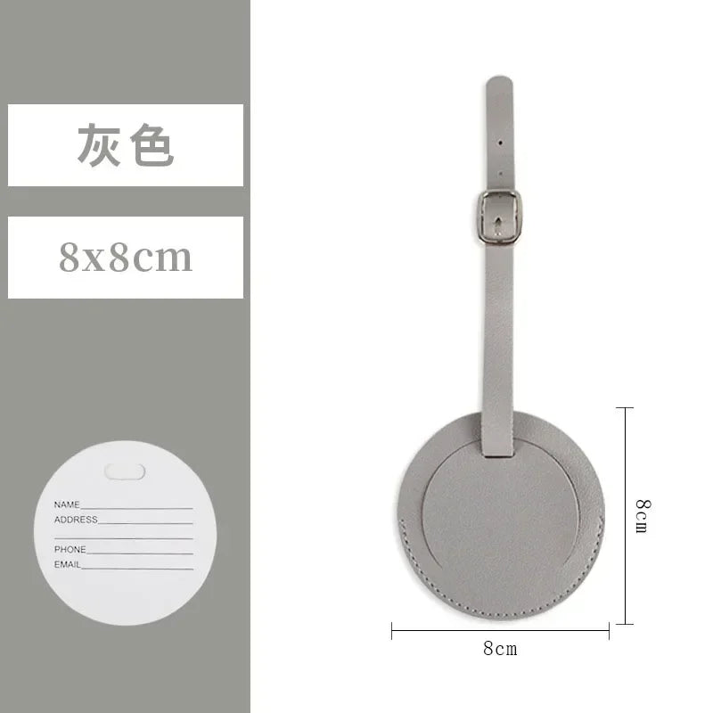A vertical gray PU leather luggage tag with a circular identification area and a strap.