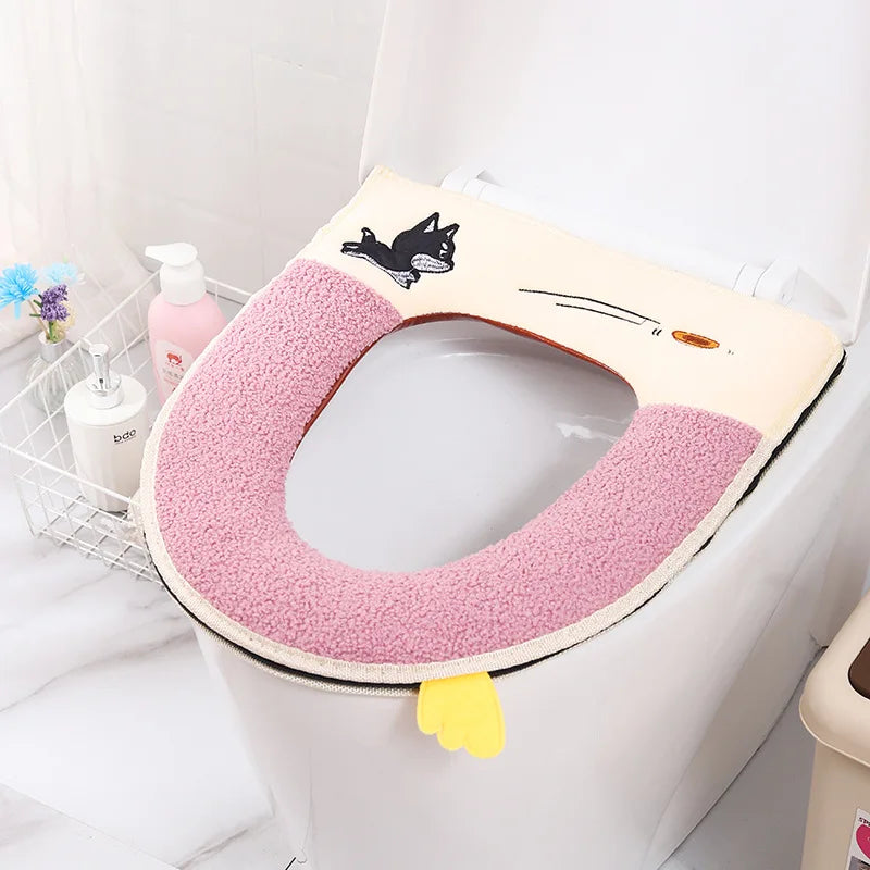 A plush pink waterproof toilet seat cover with a black cat design is shown on a white toilet.