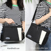 Black insulated reusable lunch bag shown in handheld and single shoulder use with a striped shirt.
